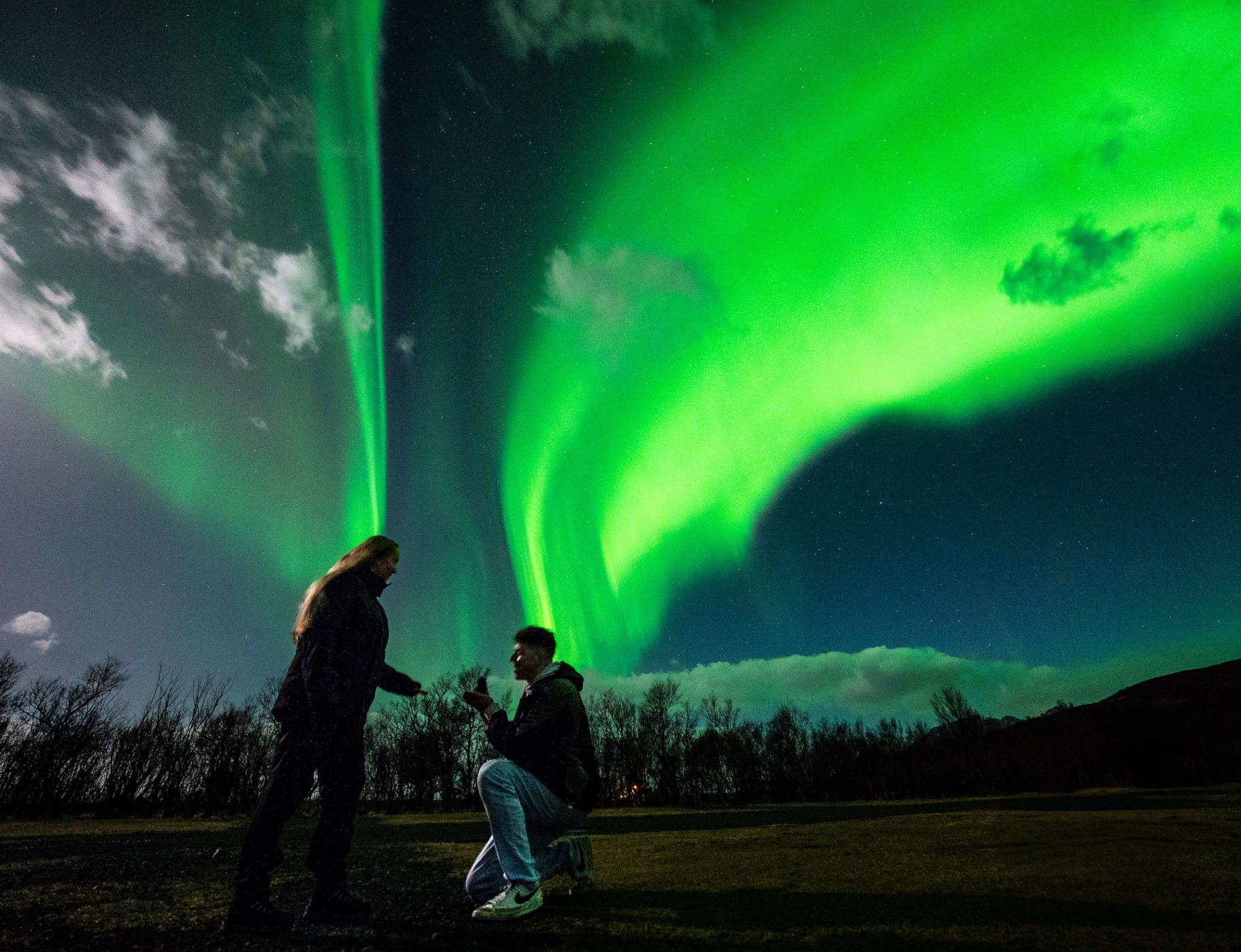 Couple proposing beneath the aurora borealis in Northumberland