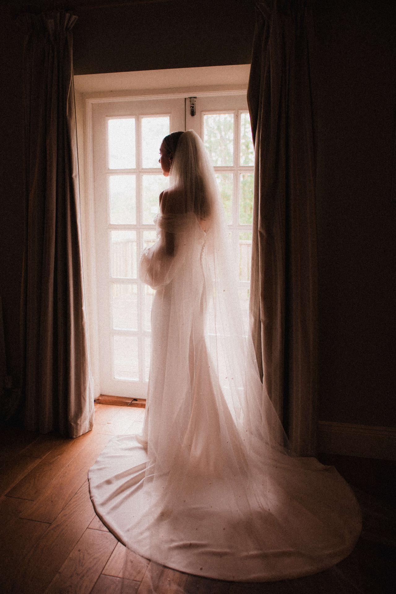 Bride preparing by a window in soft daylight